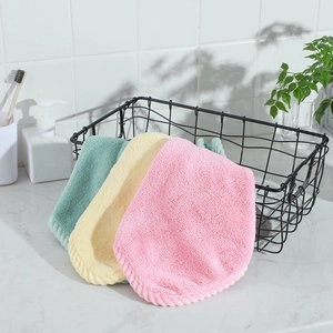Close-up of pink, yellow and green coral fleece hand towels in a black metal basket