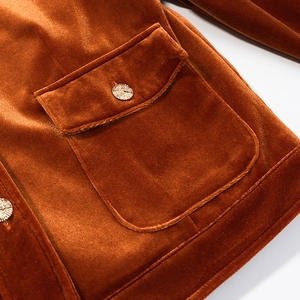 Caramel velvet jacket detail featuring a flap pocket with textured gold metal button