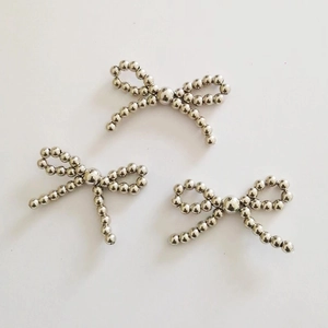 Detailed view of three silver beaded metal bow accessories for DIY apparel and headwear