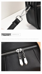 Detail of silver dual zippers and hardware hooks on a black lychee texture leather bag