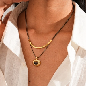 Detail of 18k gold plated double-layer necklace featuring a tiger eye stone pendant