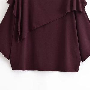 Deep burgundy long sleeve top with layered ruffles and flowing draped fabric texture