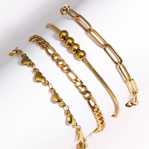 Détail d'un ensemble de quatre bracelets dorés incluant des mailles cubaines et serpent