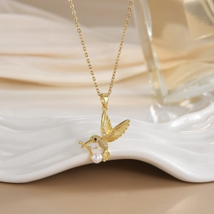 Detailed close-up of hummingbird pendant with cubic zirconia and a white round pearl