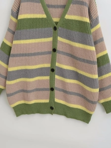 Detailed view of heavy-knit colorful striped cardigan with black buttons and V-neckline