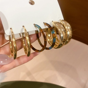 Detail shot of gold hoop earrings and amber resin hoops on a jewelry display card