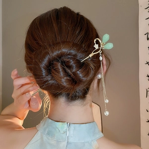 Vue détaillée d'une élégante épingle à cheveux chinoise avec pompon de perles sur un chignon