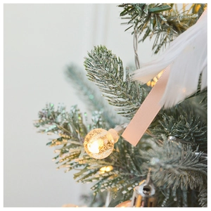 Detail of warm white LED string lights on a pink Christmas tree with feather accents