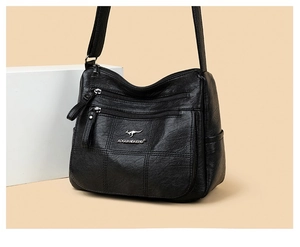 Detail view of the black multi-layer leather crossbody bag with kangaroo logo engraving
