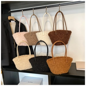 Sept couleurs de sacs cabas en laine d'agneau rose gris et marron suspendus sur un présentoir