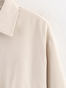 Detailed close-up of beige twill jacket showing premium stitching and collar texture