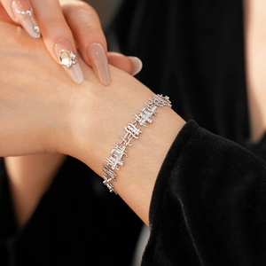 Close-up of geometric silver chain bracelet featuring zircon stones on a model wrist