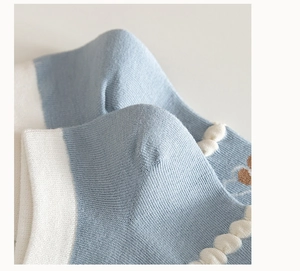 Dettaglio ravvicinato di calzino in cotone pettinato azzurro con bordo a onde e tallone