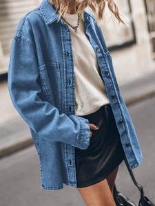 Detail of loose fit denim shirt showing classic blue wash texture and large pockets