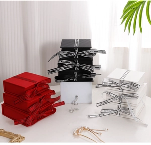 Detailed stack of multi-color flip-top jewelry gift boxes with Best Wishes ribbon