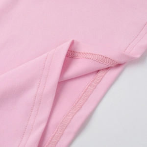 Vue détaillée des coutures doubles et de la texture en maille rose sur l'ourlet du haut