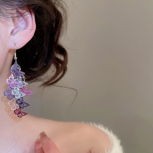 Vue détaillée de boucles d'oreilles papillon à pampilles colorées et dégradées sur modèle