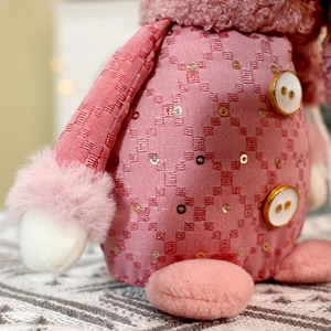 Macro detail of pink sequin fabric and plush white cuffs on Christmas dolls