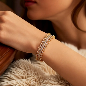 Detail of 18k gold plated multi-row crystal bracelet on white faux fur background