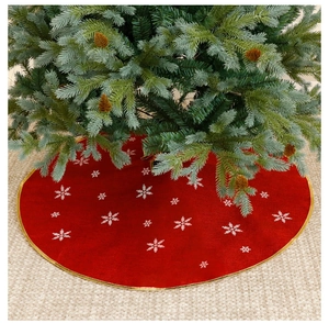 Detail of red Christmas tree skirt with white snowflakes and gold ribbon edges