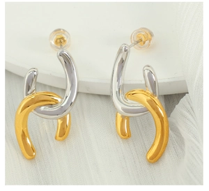 Macro shot of geometric intertwined chain earrings in gold and silver finish