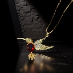Golden hummingbird pendant necklace with red teardrop gem and white zircon on box chain