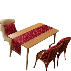 Red Christmas table runner with snowflake and reindeer patterns on a wooden table