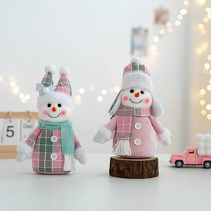 Close-up of two plush Christmas snowmen dolls in pink and green plaid festive outfits