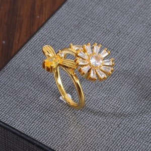 Detail of a rotating golden bee and daisy ring with yellow zircons and micro-inlays