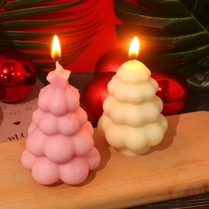 Detailweergave van brandende kerstboomkaarsen in de kleuren zachtroze en crèmewit