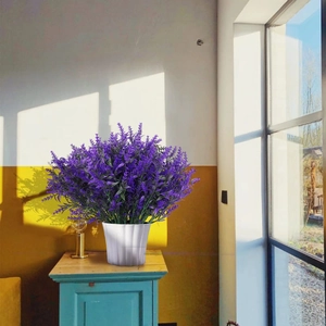 Detail of purple artificial lavender in a white striped pot on a vintage wooden cabinet