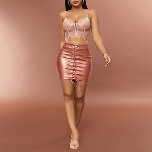 Detail of pink metallic faux leather mini skirt with lace-up side and hollow out lace bodysuit