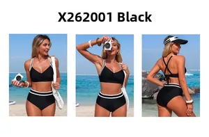 Three-way view of a black two-piece swimsuit with white contrast trim on a sunny beach