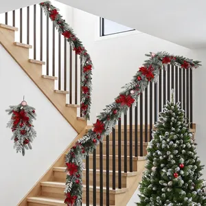 Christmas garland with red velvet flowers and snow coating on a staircase banister