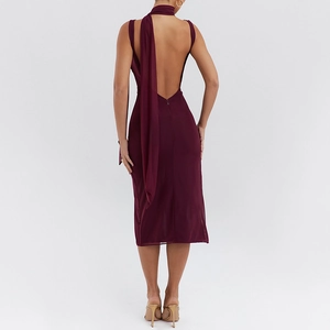 Detail of the backless cowl neck dress featuring mesh patchwork and a deep red hue