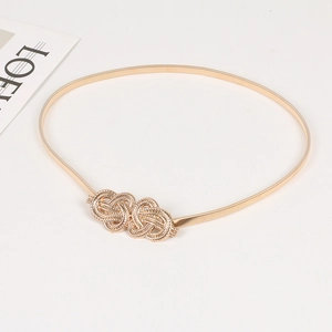 Detailed close-up of a gold elastic metal waist chain with a delicate woven double knot buckle