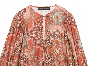 Dettagli del top bohémien con stampa paisley, scollo con lacci e tessuto rosso ruggine