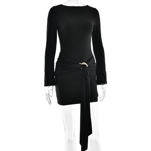 Detail of black mini dress featuring a decorative gold ring buckle and elegant draping