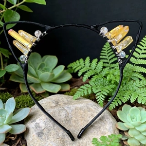 Detailed view of handmade cat ear headband with yellow crystal stones and black wire frame