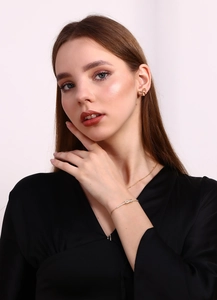 Detail view of 18K gold plated bow jewelry set with zircon crystals worn by a model