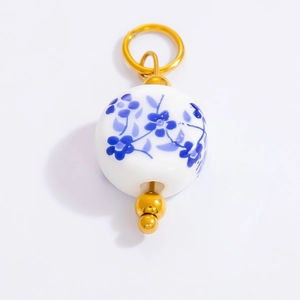 Blue and white porcelain floral ceramic pendant charm with golden metal accents