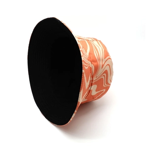 Detail of graffiti bucket hat with orange marble pattern and black lining with stitching