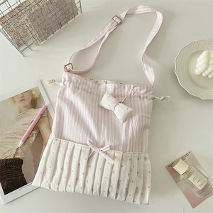 Detail of pink and white striped fabric crossbody bag with sweet bows and ruffles