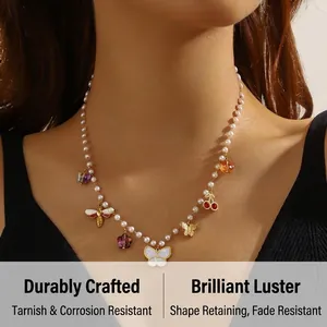 Detail of pearl chain necklace with butterfly, bee and cherry charms on model