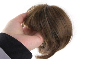 Detailed close-up showing texture and gloss of brown synthetic hair wig for pets