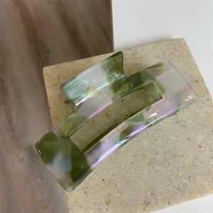 Detailed view of the green marble texture and glossy finish on the acetate hair claw clip