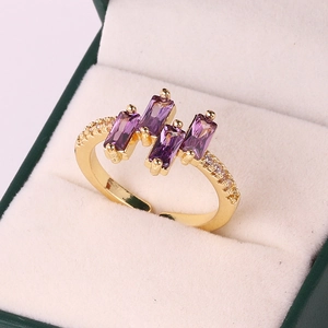 Close-up of gold-plated ring featuring four rectangular purple zircons in a jewelry box