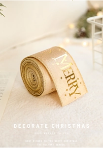 Detail of champagne gold Christmas ribbon with metallic star print and Merry lettering