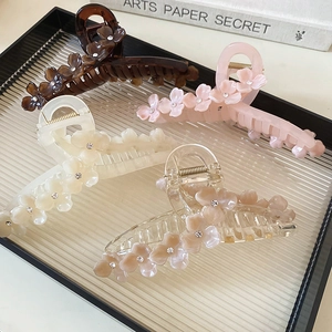 Quatre pinces à cheveux fleurs en résine avec strass sur un plateau en verre pour femme
