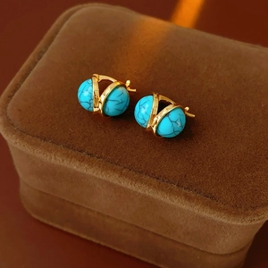 Vue détaillée des boucles d'oreilles vintage en résine avec perles turquoise et métal doré